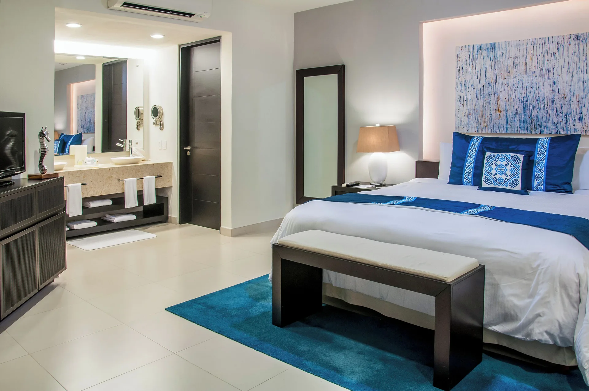 Three-Bedroom Villa bedroom with king bed and open vanity at Marival Distinct World Spa.