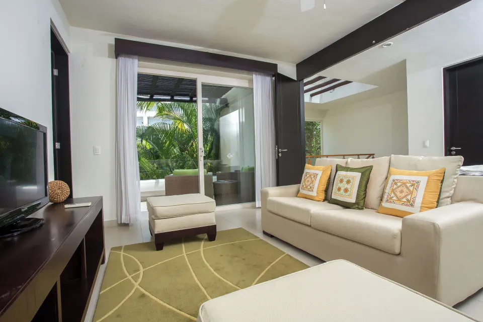 Three-Bedroom Villa lounge with sofa and terrace doors at Marival Distinct World Spa.