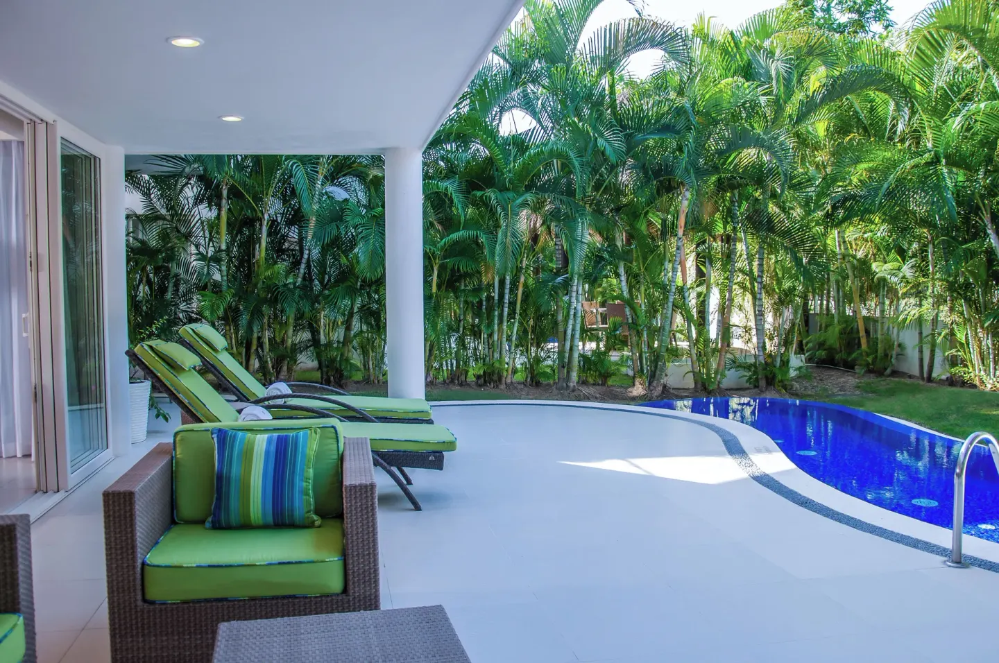 Three-Bedroom Villa terrace with pool, loungers, and palms at Marival Distinct World Spa.