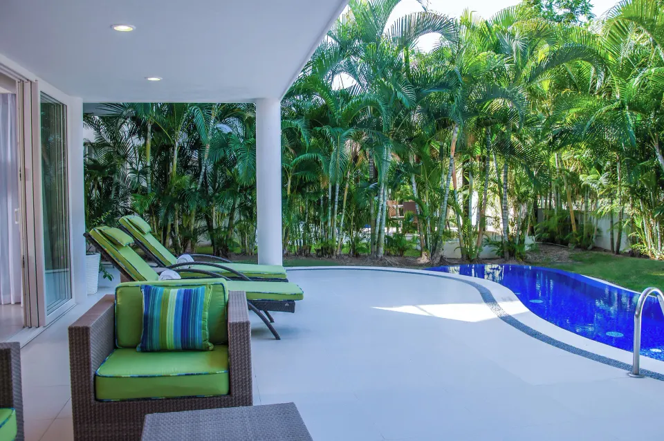 Three-Bedroom Villa terrace with pool, loungers, and palms at Marival Distinct World Spa.