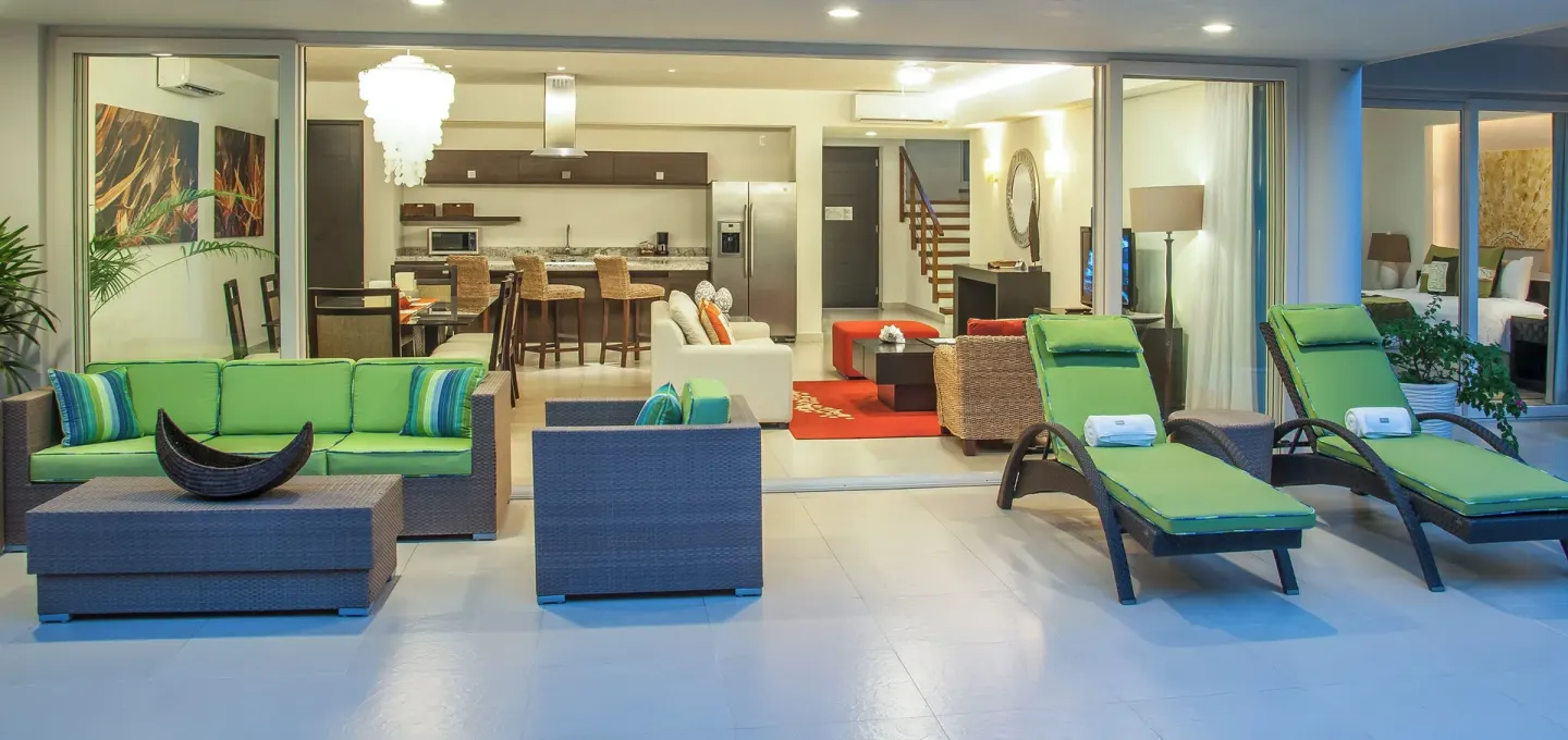 Three-Bedroom Villa terrace with lounge chairs and open living area at Marival Distinct World Spa.