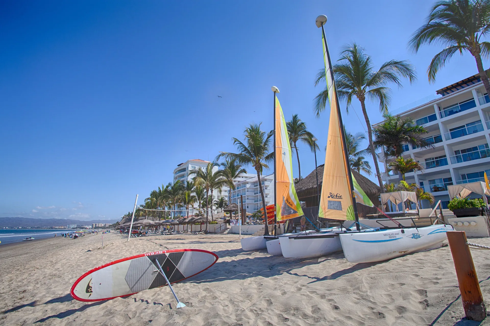 Sailboats and a paddleboard rest on the sandy beach at Marival Emotions Resort.