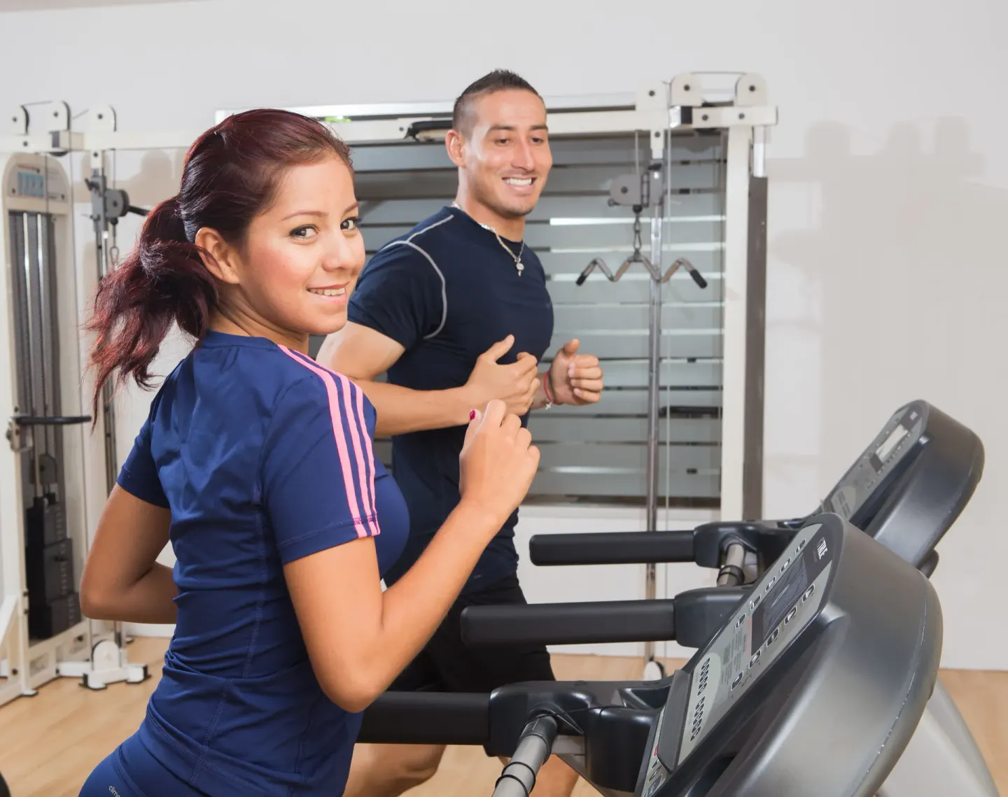 Two guests run on treadmills in the fitness room at Marival Emotions Resort.