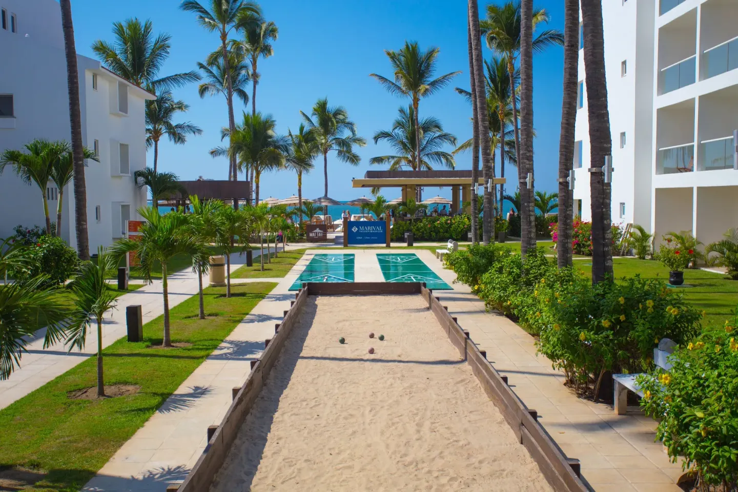 Bocce and shuffleboard courts between resort buildings at Marival Emotions Resort.