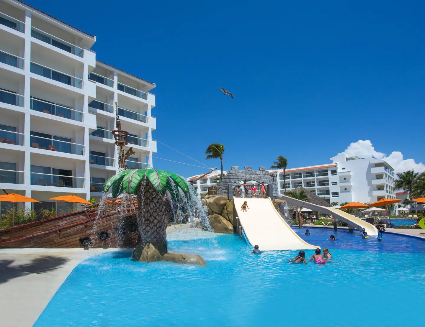 Kids pool with a ship feature, palm splash bucket, and waterslides at Marival Emotions Resort.