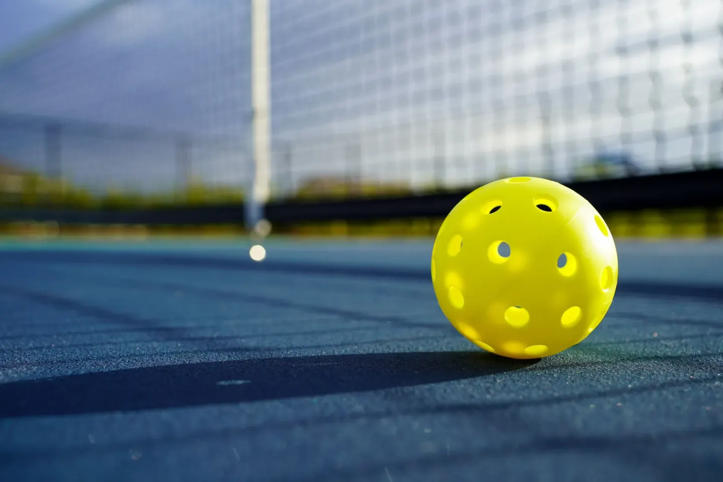 Yellow pickleball on a court near the net at Marival Emotions Resort.