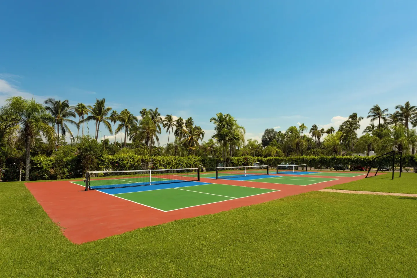 Pickleball courts set in green lawns at Marival Emotions Resort.