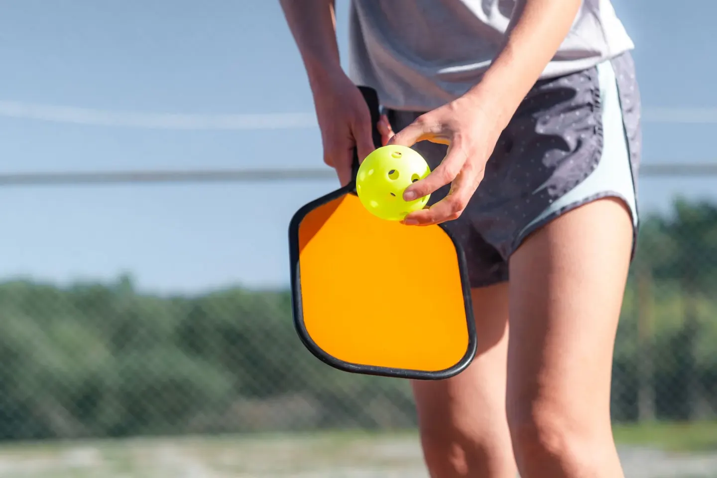 Pickleball paddle and ball held outdoors at Marival Emotions Resort.