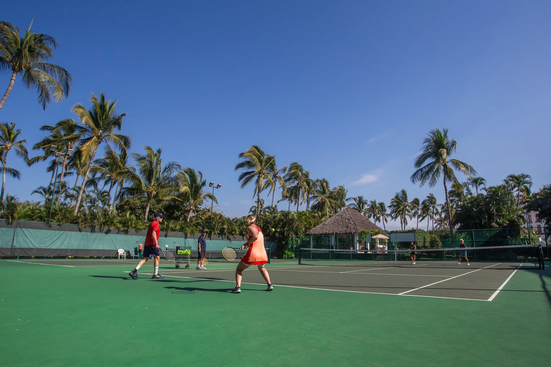Guests playing tennis on an outdoor court at Marival Emotions Resort.