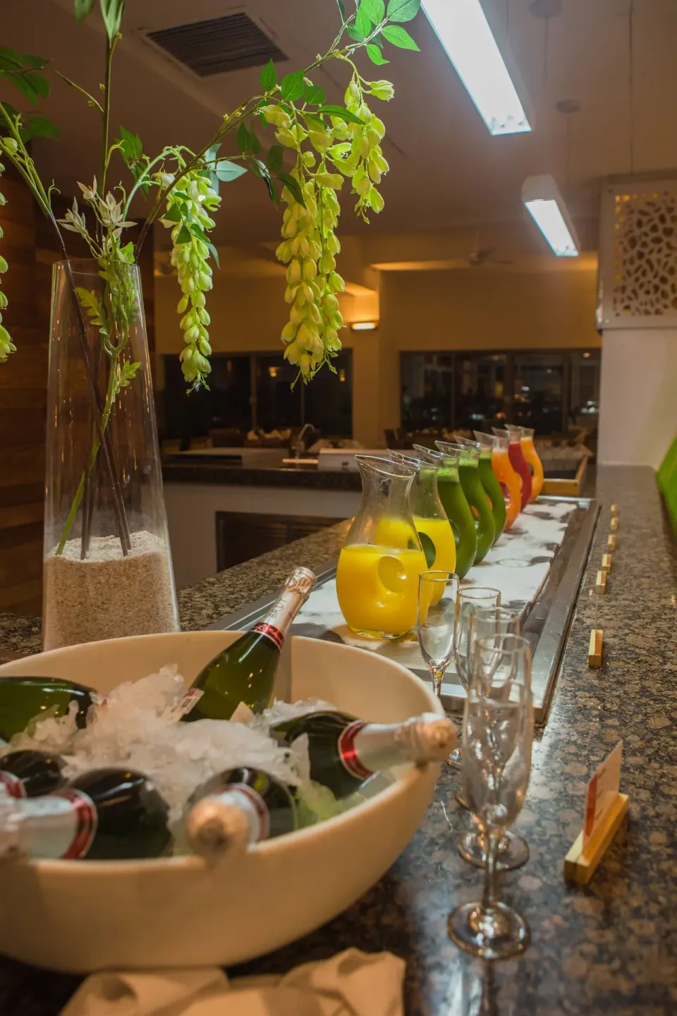 Juices, sparkling wine, and glasses lined up on a bar at Marival Emotions Resort.