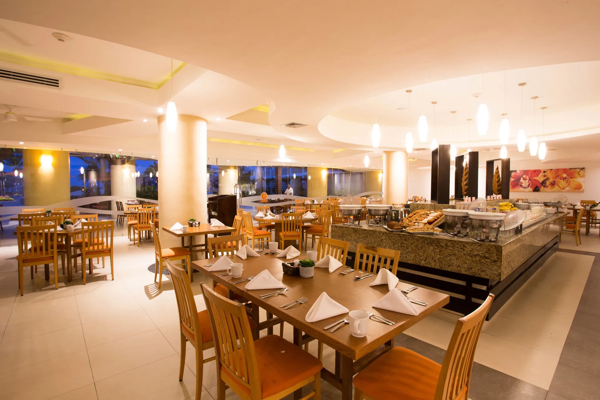 Buffet dining room with wooden tables and serving stations at Marival Emotions Resort.