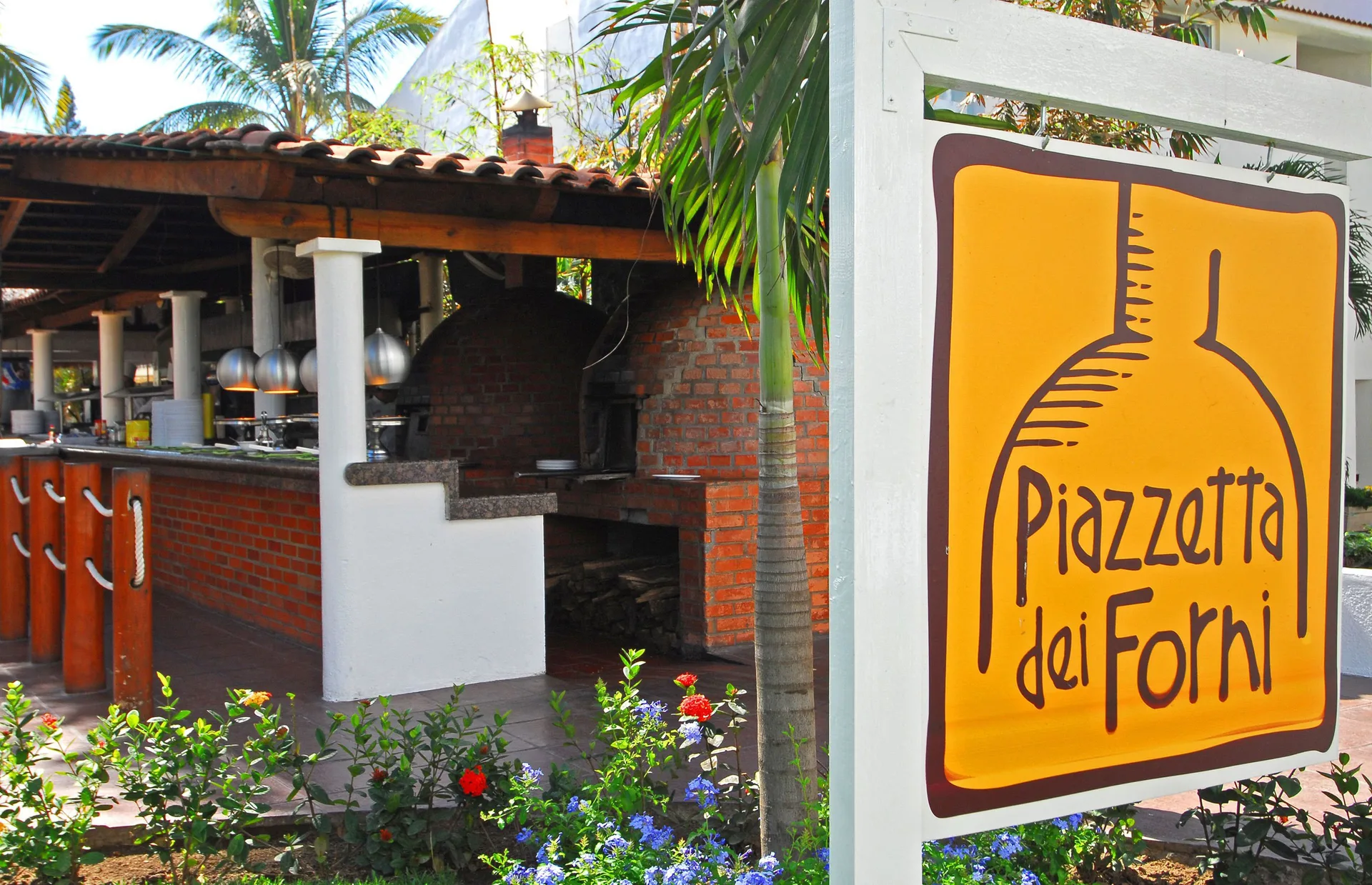 Piazzetta dei Forni sign beside an outdoor brick pizza oven at Marival Emotions Resort.