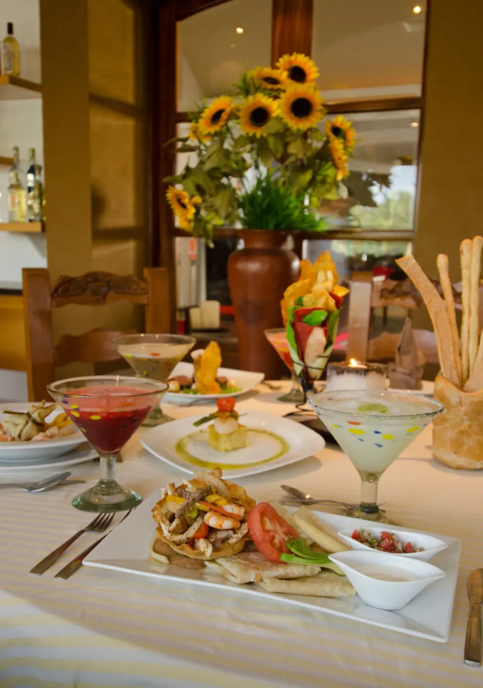 Seafood plate with cocktails, appetizers, breadsticks, and sunflowers at Marival Emotions Resort.