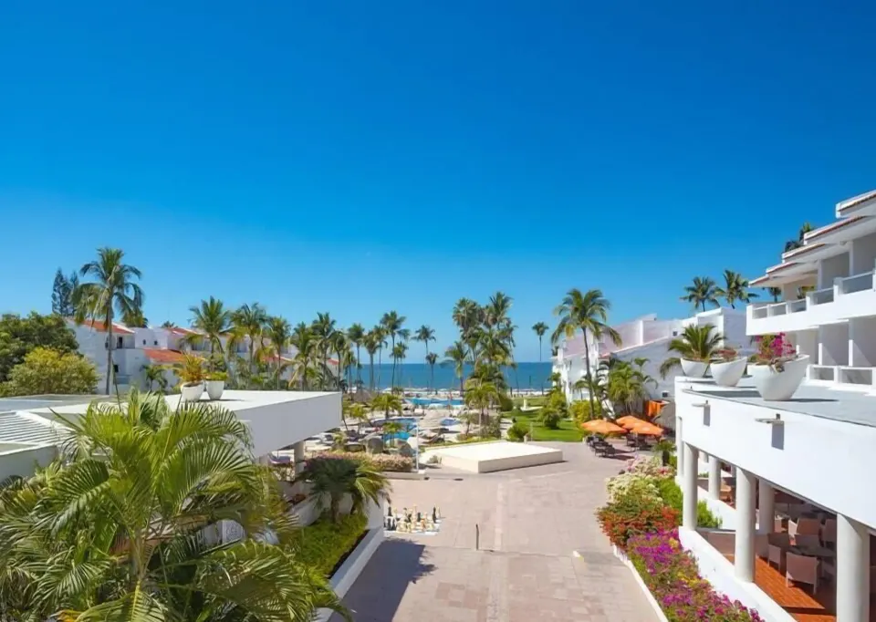 Balcony view over palms, resort buildings and ocean at Marival Emotions Resort.
