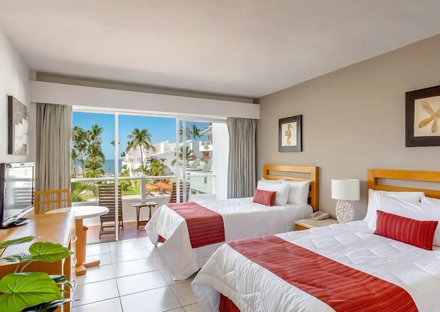 Club Room with two beds, balcony seating and ocean view at Marival Emotions Resort.