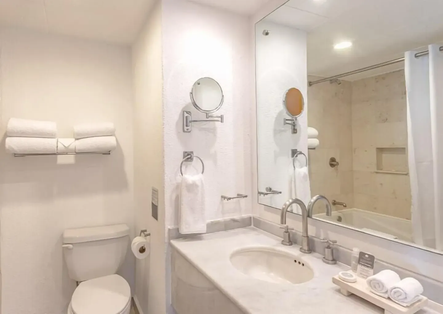 Club Room bathroom with sink, mirror, towels and tub at Marival Emotions Resort.