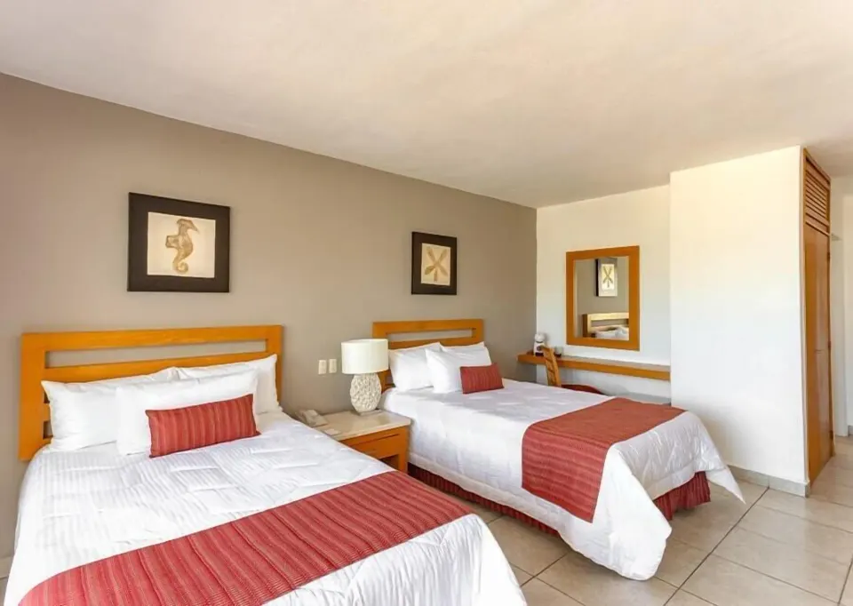 Club Room with two beds, wall art and vanity area at Marival Emotions Resort.