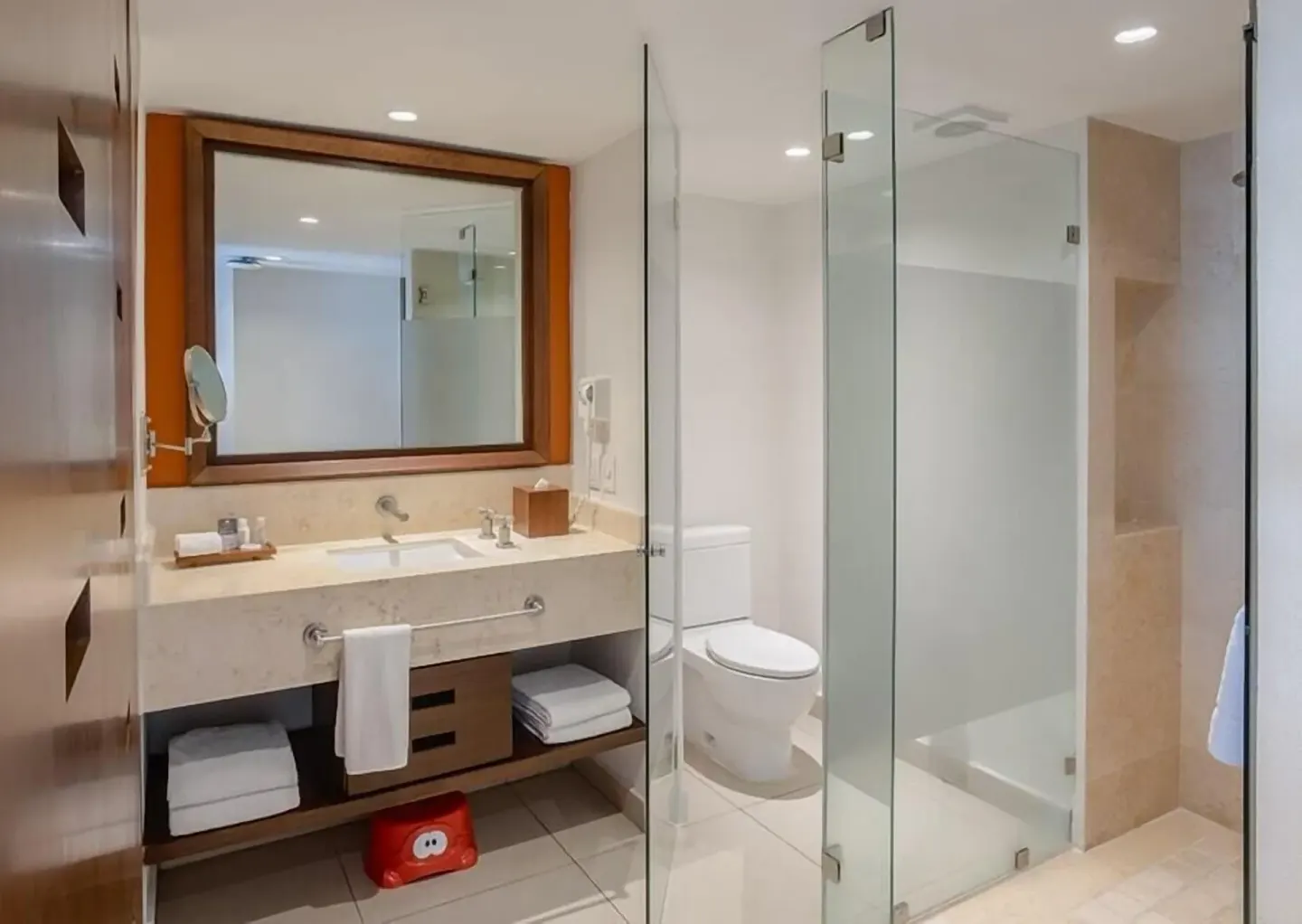 Grand Room bathroom with vanity, toilet, and glass shower at Marival Emotions Resort.