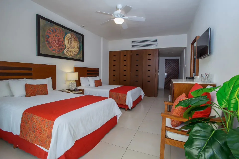 Grand Room with two beds, seating, TV, and wardrobe at Marival Emotions Resort.