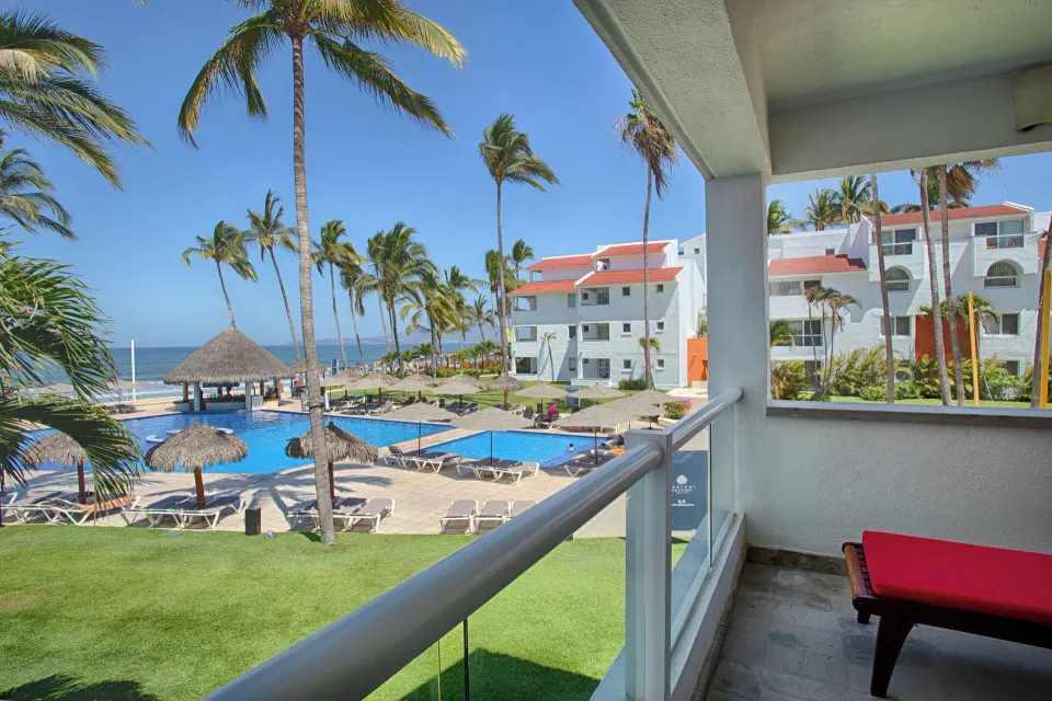 Oceanfront suite balcony view of pools and palms at Marival Emotions Resort.