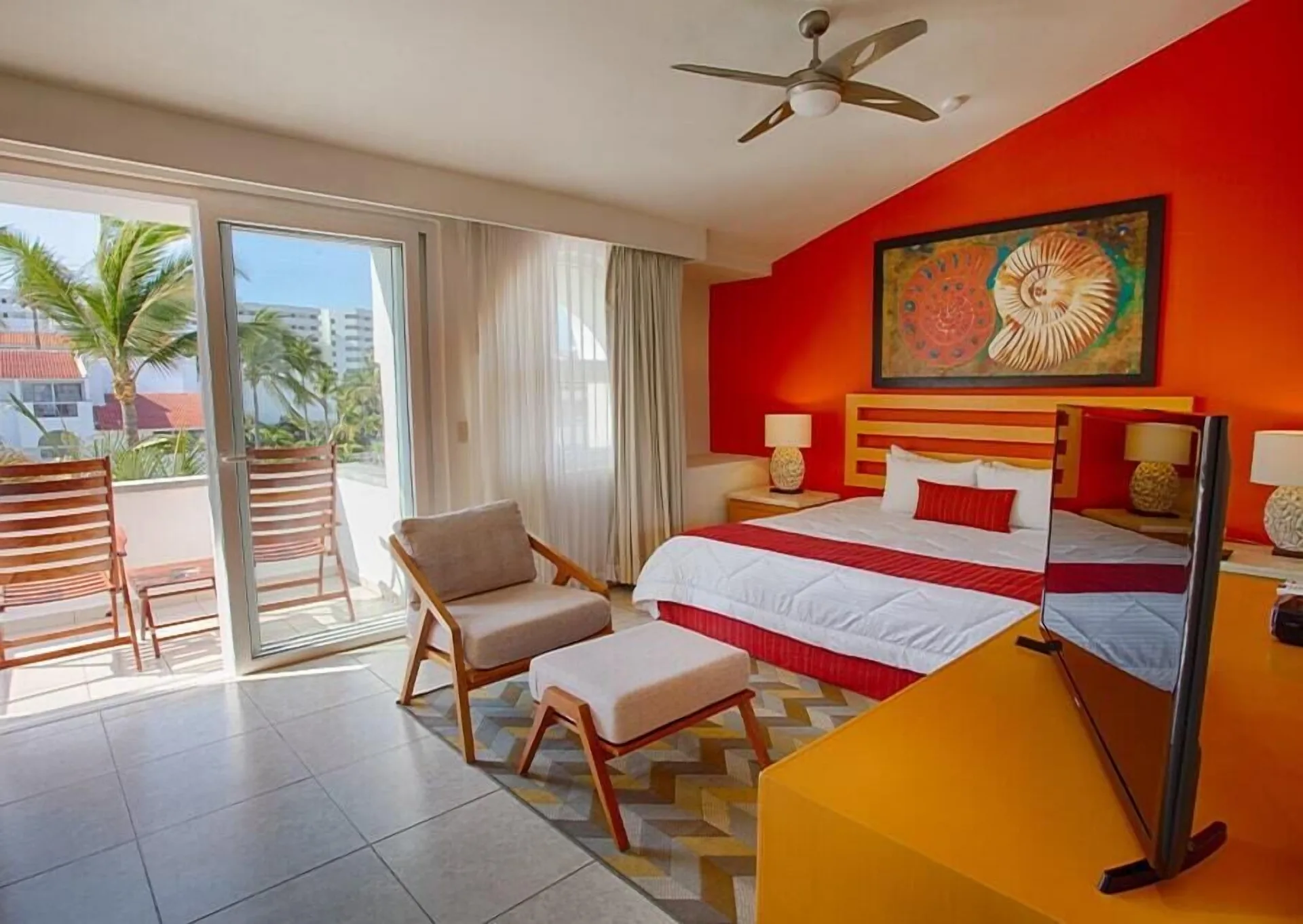 Two-bedroom balcony suite bedroom with king bed and terrace seating at Marival Emotions Resort.