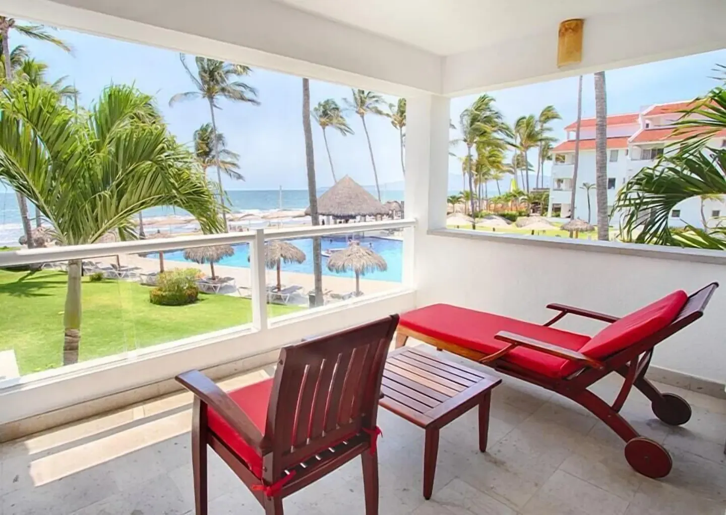Oceanfront balcony with red lounge seating at Marival Emotions Resort.