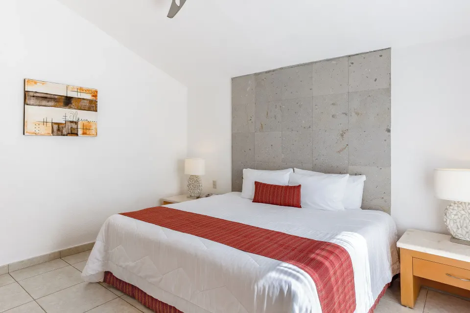 King bedroom with red bed runner and wall art at Marival Emotions Resort.