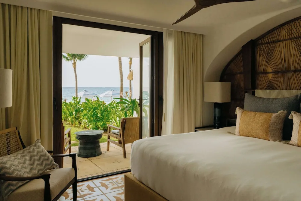 Beachfront king bed guest room with open terrace doors at Maroma, Riviera Maya.