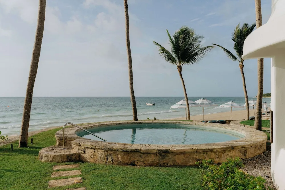 Round stone plunge pool beside the beach and palms at Maroma, Riviera Maya.