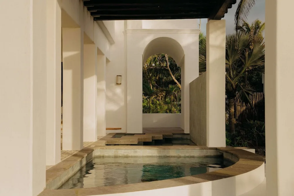 Covered terrace with a plunge pool and garden archway at Maroma, Riviera Maya.