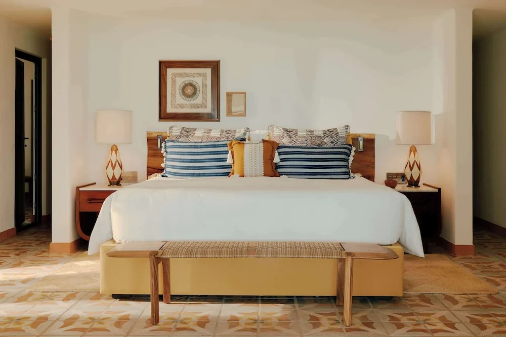 King bed with patterned pillows and bedside lamps at Maroma, Riviera Maya.