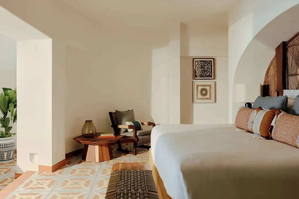 King bed and sitting nook in a bright guest room at Maroma, Riviera Maya.