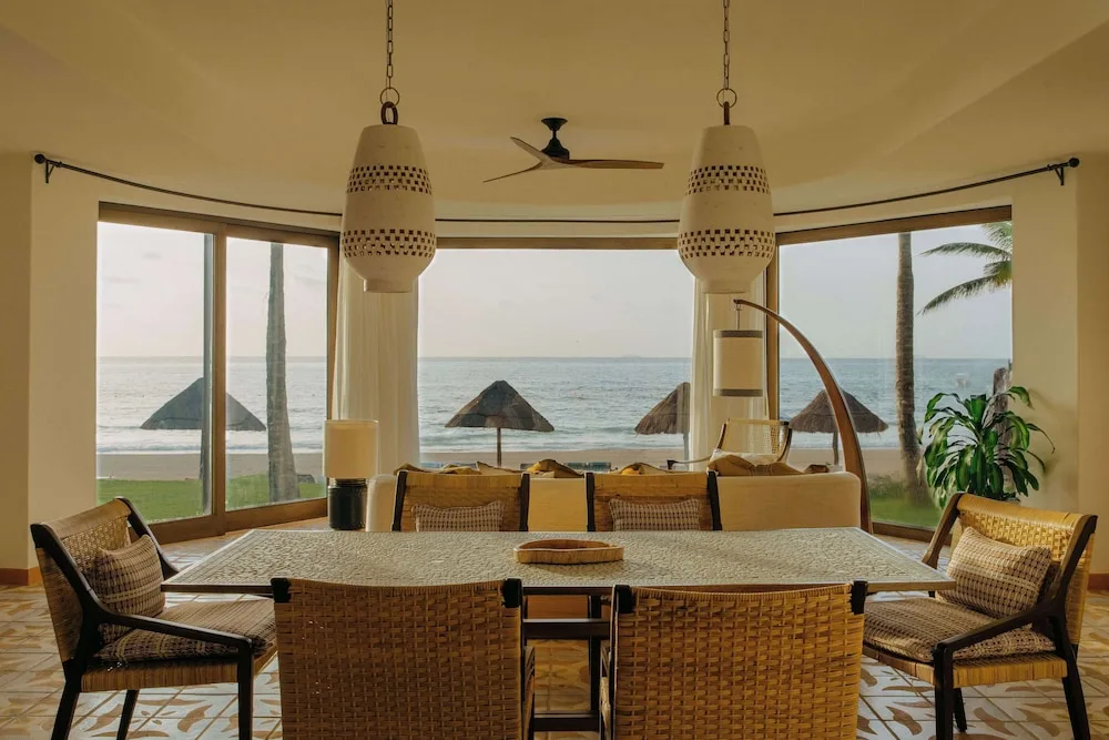 Oceanfront living and dining area with large windows at Maroma, Riviera Maya.