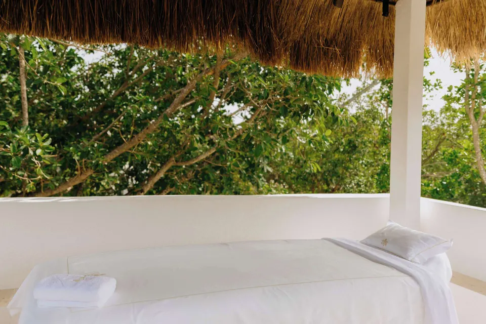 Outdoor spa treatment bed under a thatched roof at Maroma, Riviera Maya.
