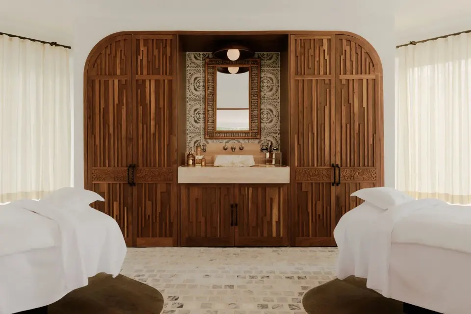Two spa treatment beds face a wood-paneled vanity at Maroma, Riviera Maya.