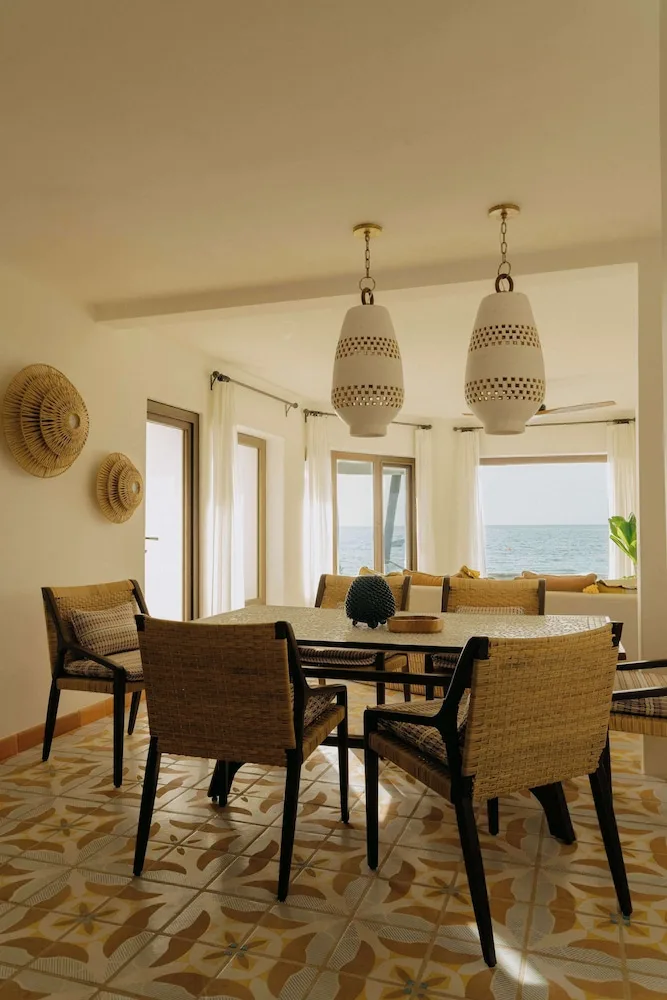 Dining table and ocean-facing lounge in a suite at Maroma, Riviera Maya.