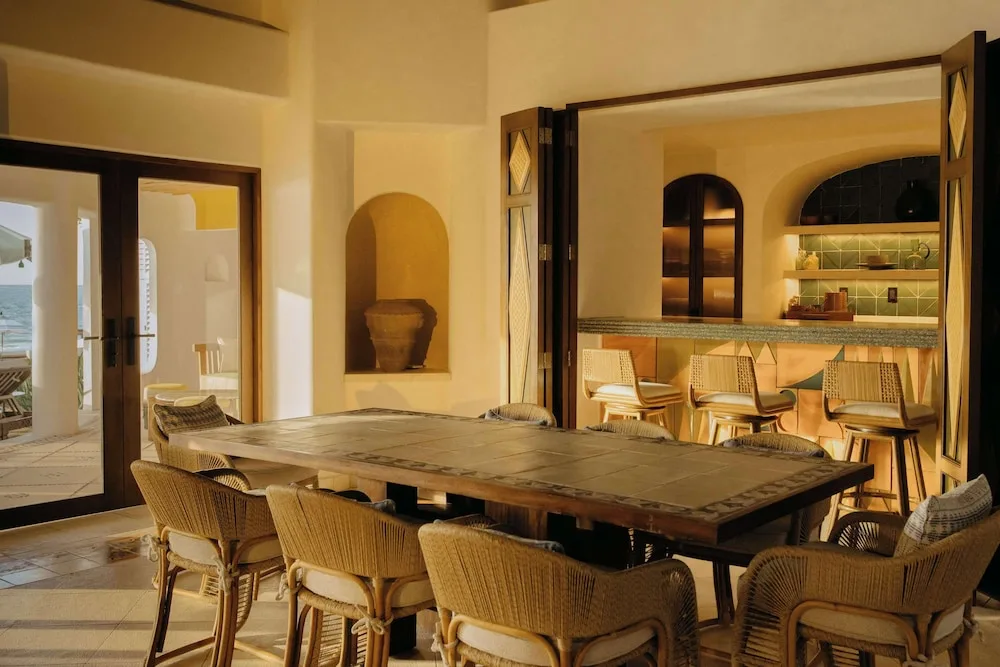 Dining table and bar counter in a warm indoor-outdoor space at Maroma, Riviera Maya.