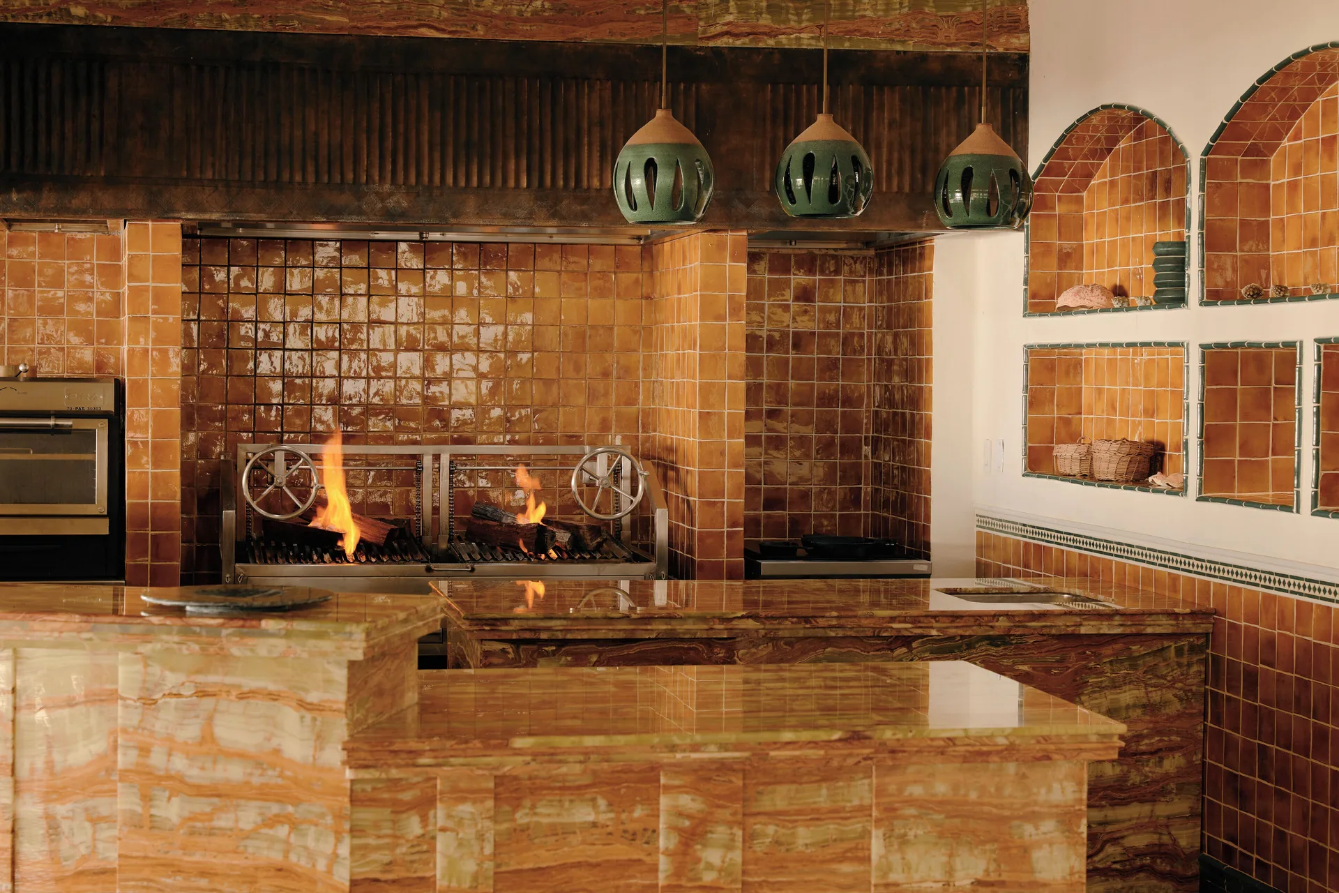 Open kitchen with live-fire grill and terracotta tile at Maroma, Riviera Maya.