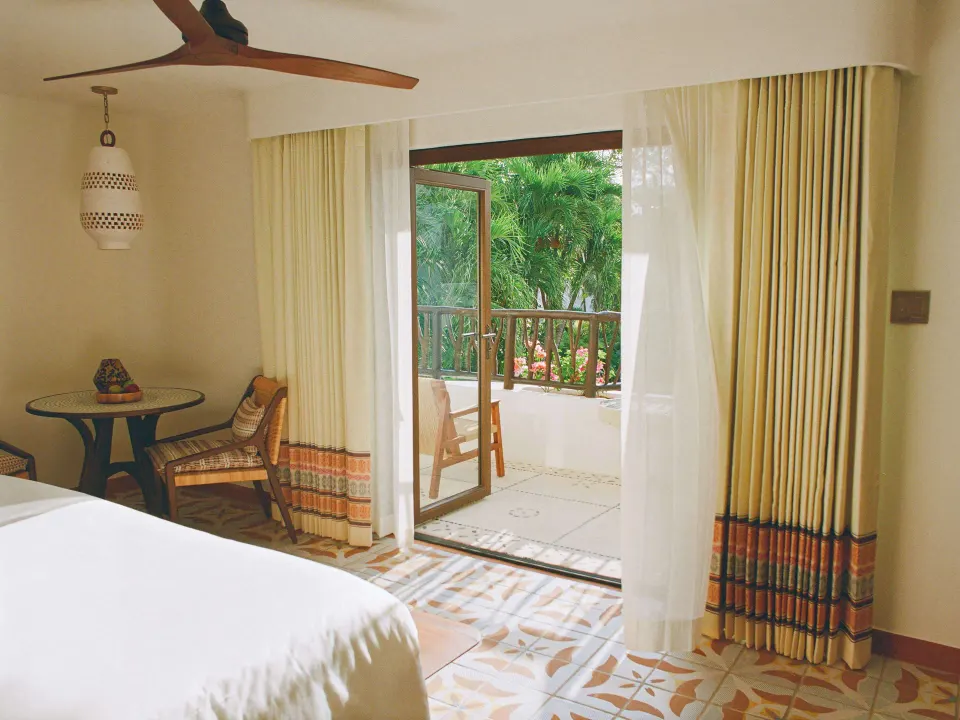 Deluxe Garden View Room seating area and open balcony doors at Maroma, Riviera Maya.