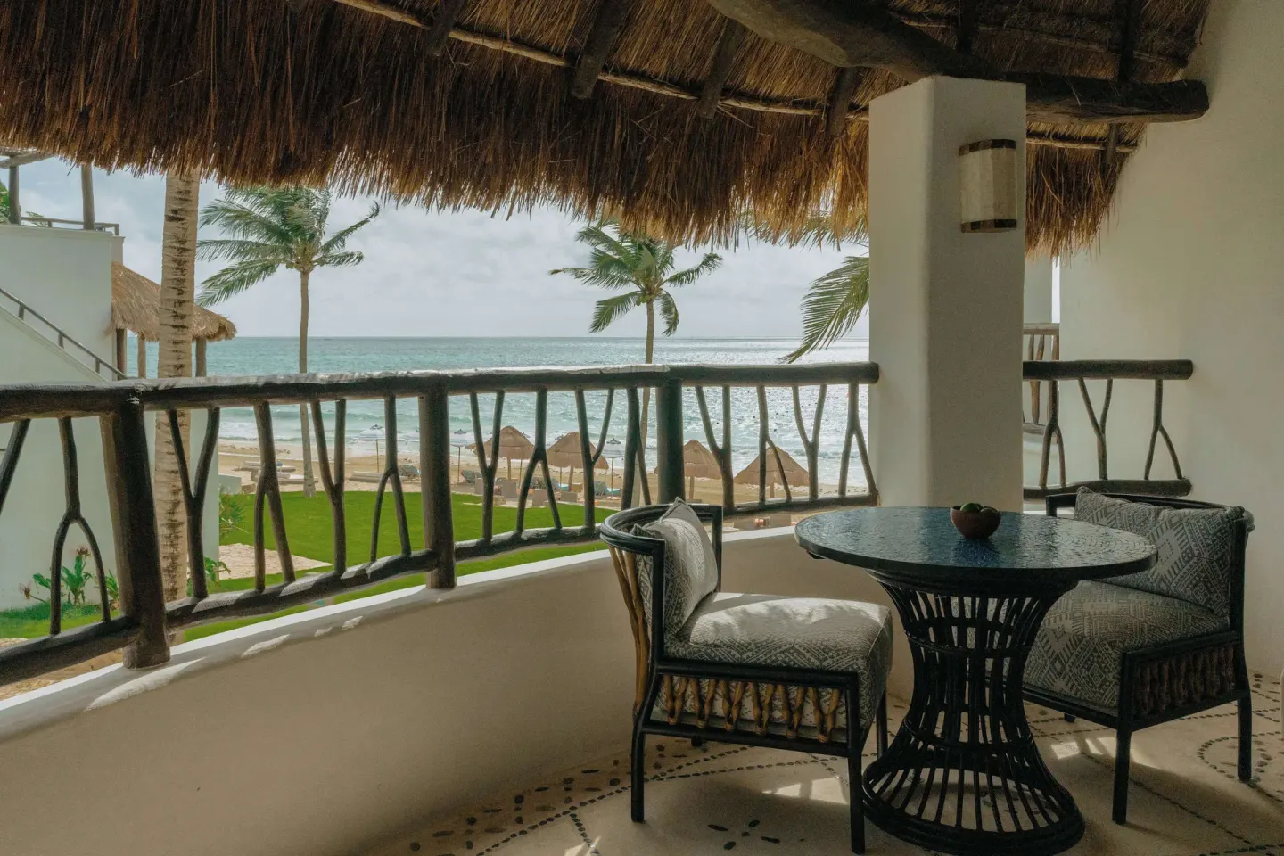 Ocean-view balcony with seating outside a Deluxe Room at Maroma, Riviera Maya.
