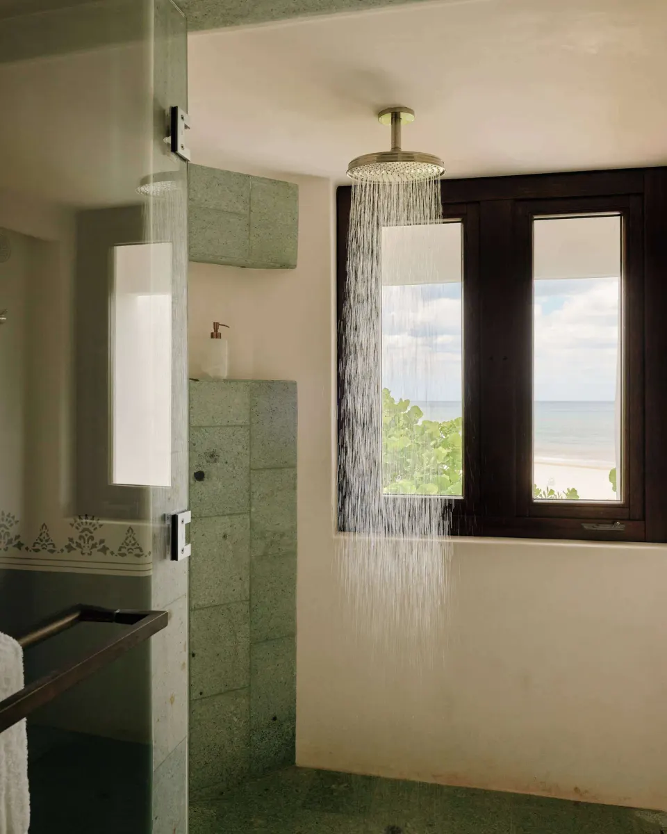 Deluxe Ocean View Room bathroom shower with sea view window at Maroma, Riviera Maya.