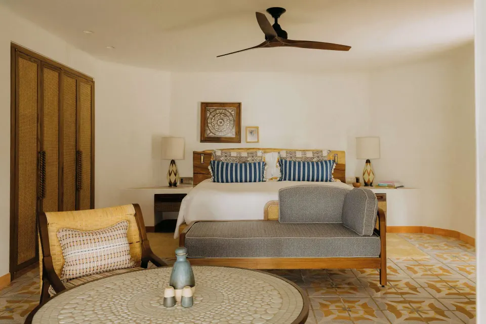 Deluxe Ocean View Room bedroom with king bed and sitting area at Maroma, Riviera Maya.