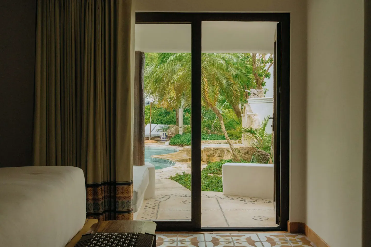 Junior Suite Garden View patio doors open to palms and a plunge pool at Maroma, Riviera Maya.