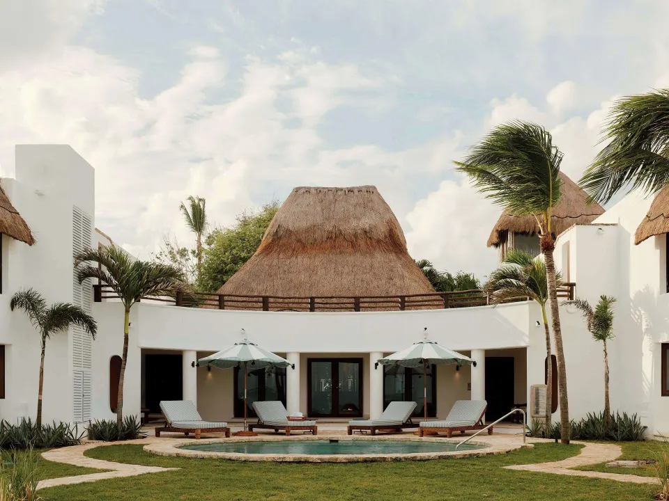Villa Maroma exterior with plunge pool, loungers and thatched roof at Maroma, Riviera Maya.