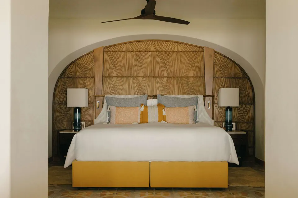 King bed with woven headboard in an oceanfront suite at Maroma, Riviera Maya.