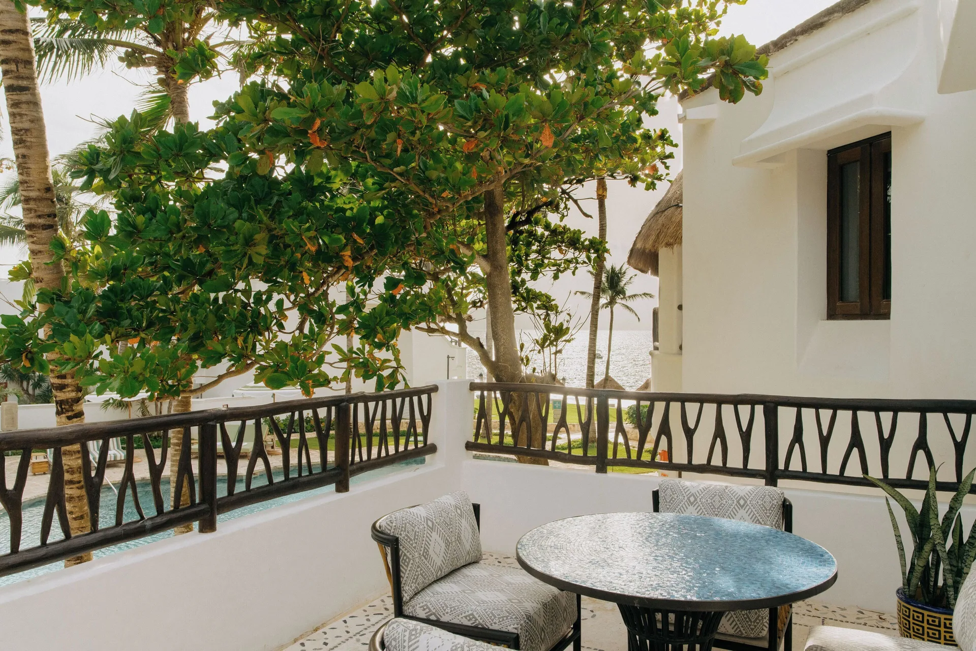 Suite balcony seating with leafy ocean glimpses at Maroma, Riviera Maya.