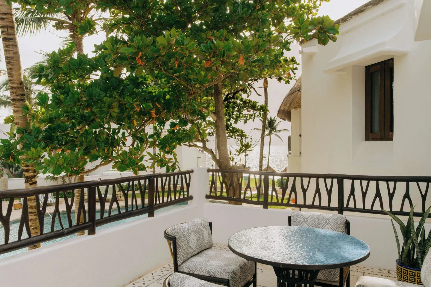 Corner suite balcony with table and tropical trees at Maroma, Riviera Maya.