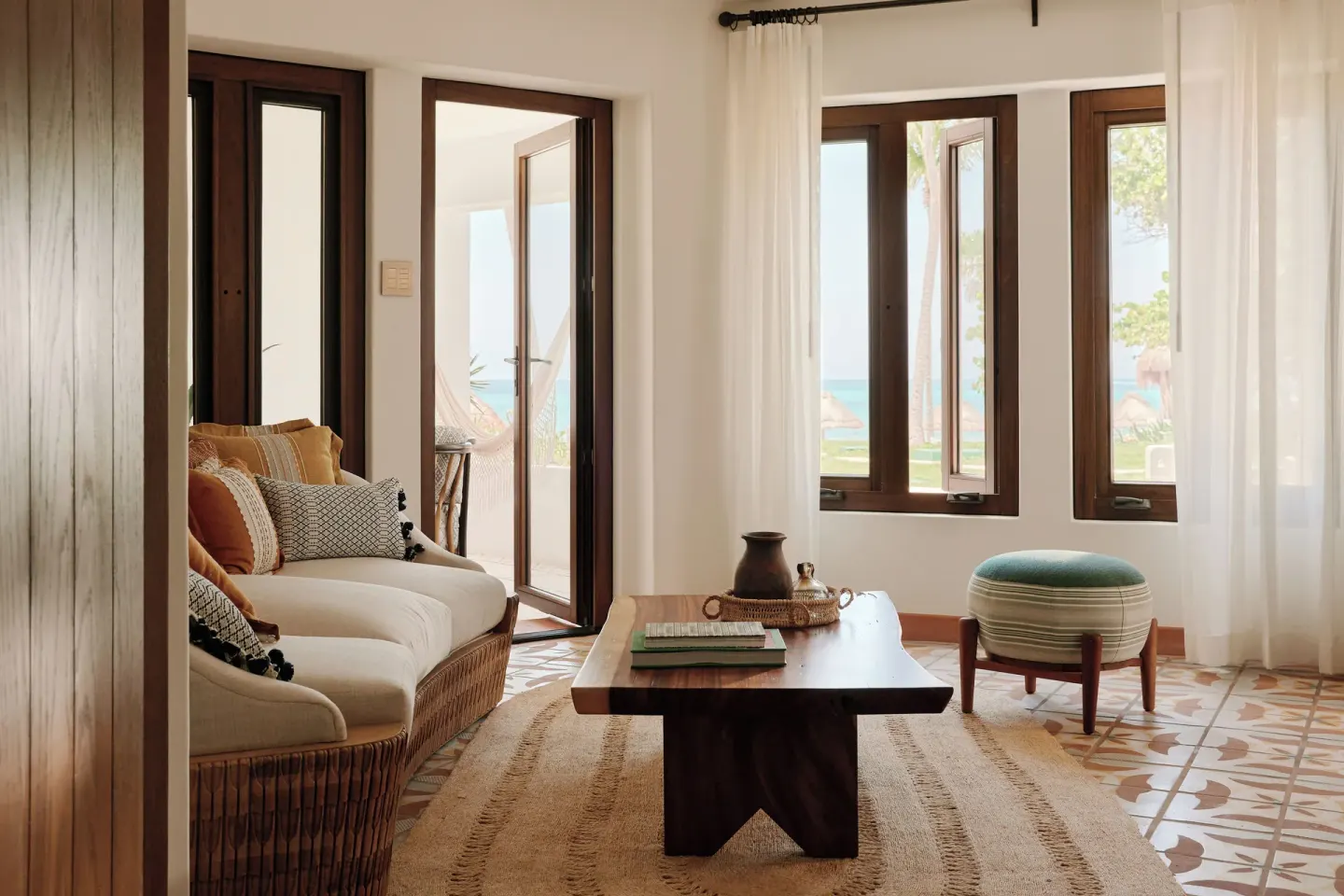 Ocean View Suite sitting area with sofa, coffee table, and sea glimpses at Maroma, Riviera Maya.