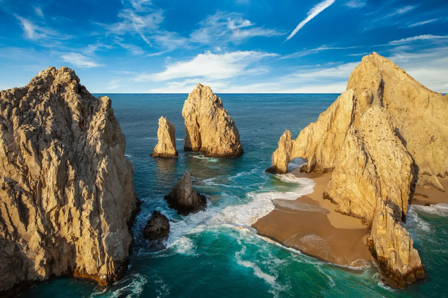 Golden rock formations and turquoise water along the Cabo coast near Marquis Los Cabos.