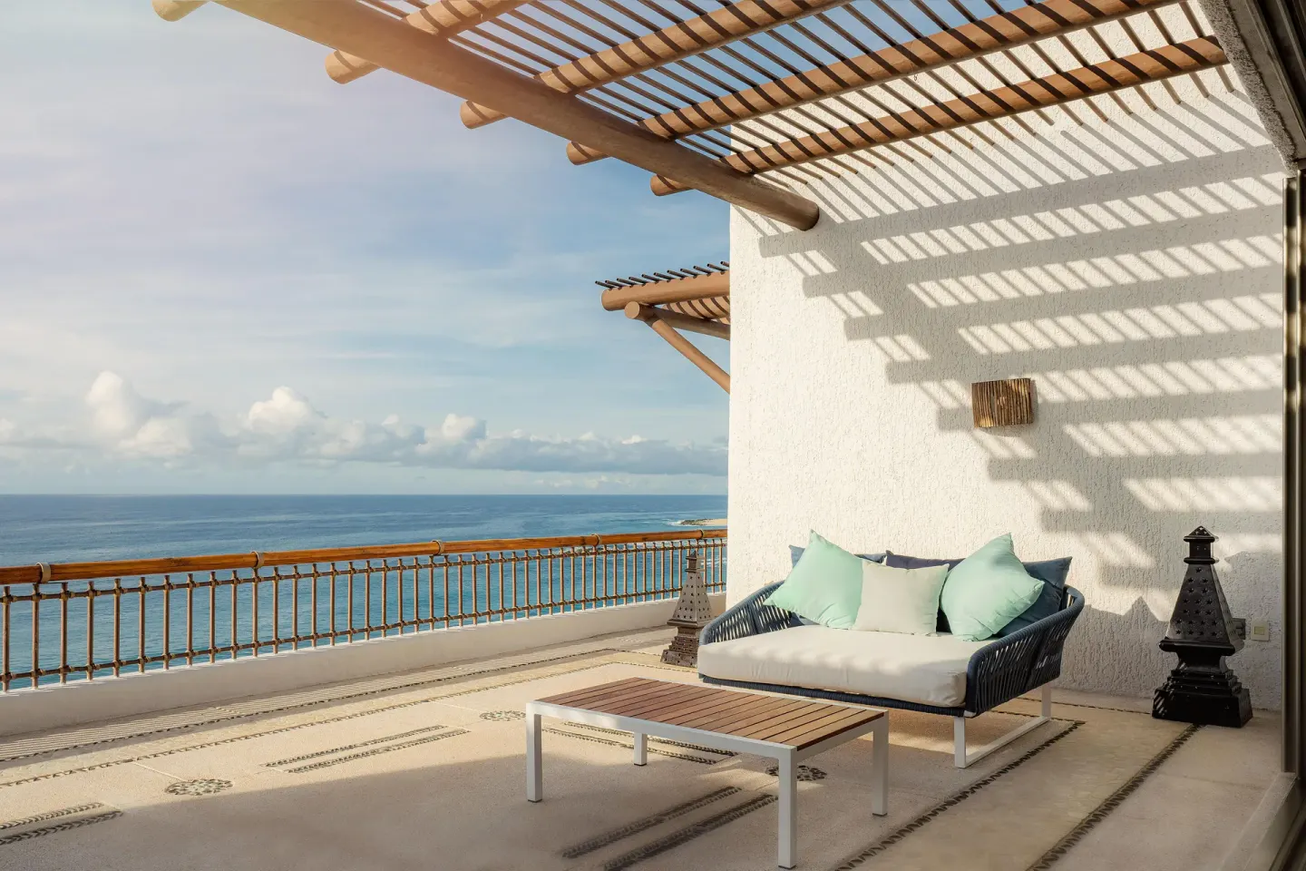 Oceanfront terrace with shaded lounge seating and pergola at Marquis Los Cabos.